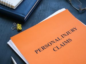 A stack of documents labeled "Personal Injury Claims" neatly arranged on a table, representing legal paperwork and case preparation.