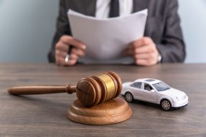 A model car and a gavel symbolize an accident lawsuit or insurance dispute. 