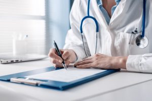 A doctor sits at her desk, carefully writing a prescription for a patient, emphasizing the importance of medical documentation.