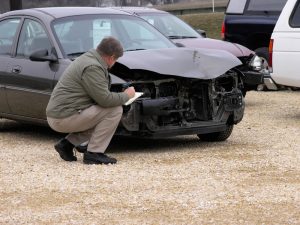 Insurance agent inspecting a vehicle for claim assessment and resolution.