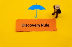 "Discovery Rule" written on a colorful slip of paper, representing key insurance, healthcare, and life insurance terminology.