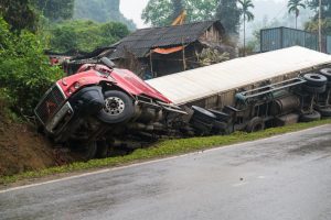 Long vehicle overturned and lying in ditch on side. Severe Truck accident on the mountainous road.