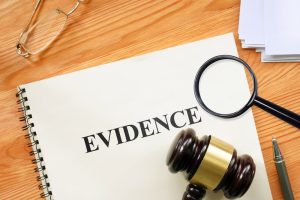 The word "Evidence" viewed through a magnifying glass on a notebook, symbolizing a business and legal concept.