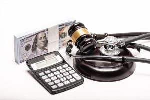 A conceptual image depicting a gavel, money, and a stethoscope to represent medical malpractice litigation.