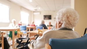 Elderly woman with foldable walker in nursing home.